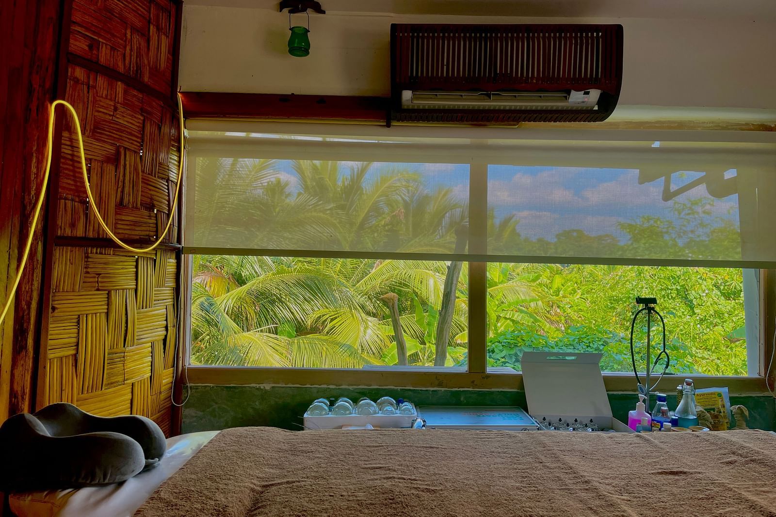 Spa at Matsya Island Retreat with a calming greenery view through a wide window, featuring spa equipment arranged below.